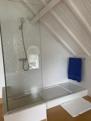 a bathroom with a shower with a blue towel at KAZARÃO DI MAVETE- Guesthouse in Praia