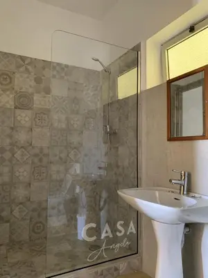 a bathroom with a sink and a glass shower at Residencial Casa Ângela in Espargos