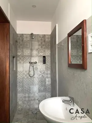 a bathroom with a white sink and a shower at Residencial Casa Ângela in Espargos