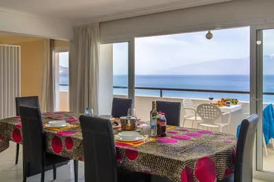 a dining room with a table and a view of the ocean at Sky Mariposa sospesa sul mare in Mindelo