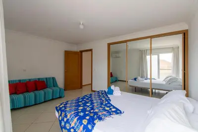 a bedroom with a bed and a blue couch at Sky Mariposa sospesa sul mare in Mindelo