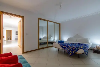 a bedroom with a bed and a large mirror at Sky Mariposa sospesa sul mare in Mindelo