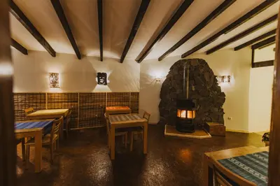 a restaurant with a stone fireplace in a room at Strela Mountain Lodge in Tarrafal