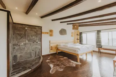 a bathroom with a shower and a bed in a room at Strela Mountain Lodge in Tarrafal