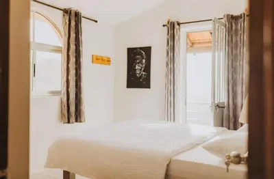 a bedroom with a white bed and a window at Strela Mountain Lodge in Tarrafal