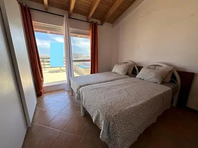 a bedroom with a bed and a large window at Spacious Penthouse with Sea View - Boteto U in Sal Rei