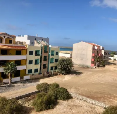 a group of buildings with palm trees and the ocean at Spacious Penthouse with Sea View - Boteto U in Sal Rei