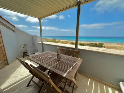 a table on a balcony with a view of the beach at Corallo Beach Front Apartments - By Bobbywashere in Santa Maria