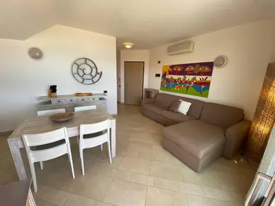 a living room with a couch and a table and chairs at Corallo Beach Front Apartments - By Bobbywashere in Santa Maria