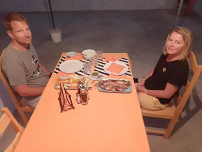 a man and woman sitting at a table with food at Pousada Cantinho de Preta in Seladinha