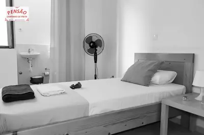 a bedroom with a large bed with a fan at Pousada Cantinho de Preta in Seladinha
