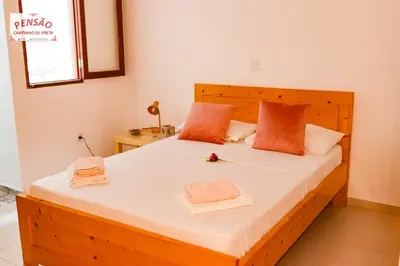 a bedroom with a wooden bed with towels on it at Pousada Cantinho de Preta in Seladinha