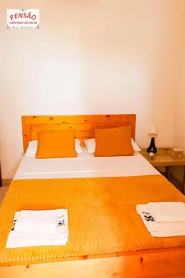 a bedroom with a bed with two towels on it at Pousada Cantinho de Preta in Seladinha