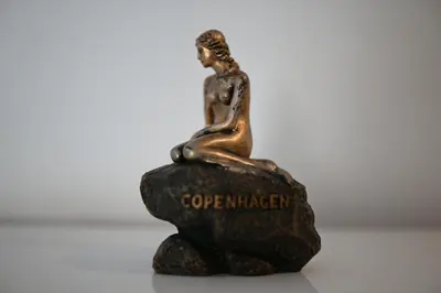a bronze figurine of a woman sitting on a rock at Casa Copenhagen - Palmarejo in Praia
