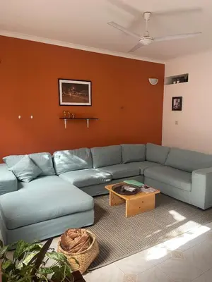 a living room with a blue couch and a table at Syds Beach House in Praia