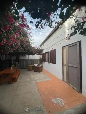 a courtyard of a building with a bench and flowers at Syds Beach House in Praia
