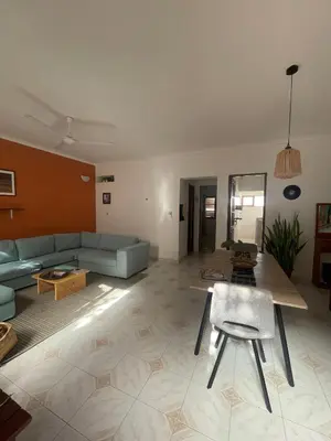 a living room with a blue couch and a table at Syds Beach House in Praia