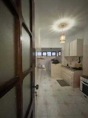 a kitchen with a door open to a room at Syds Beach House in Praia