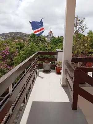 a flag flying on the balcony of a house at Hotel Viajante in Tarrafal