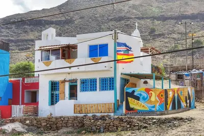 a white house with a painting on the side of it at Beach house kasa Sala mansa in Salamansa