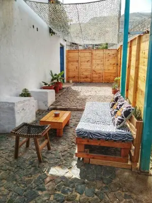 a patio with a bed and a table and a bench at Beach house kasa Sala mansa in Salamansa