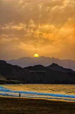 a person walking on the beach at sunset at Beach house kasa Sala mansa in Salamansa