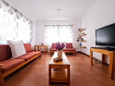 a living room with a couch and a flat screen tv at Txada Hostel in Praia