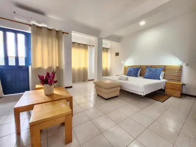a large living room with a bed and a table at Txada Hostel in Praia