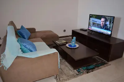 a living room with a couch and a flat screen tv at Plateau Apartment in Praia