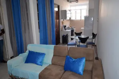 a living room with a couch with blue pillows at Plateau Apartment in Praia