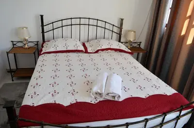 a bed with a red blanket and two towels on it at Plateau Apartment in Praia