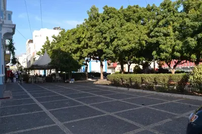a street with trees and chairs and a tent at Plateau Apartment in Praia