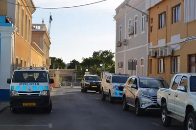 a police truck driving down a city street with cars at Plateau Apartment in Praia
