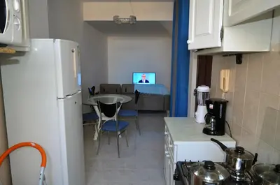 a kitchen and living room with a refrigerator and a table at Plateau Apartment in Praia