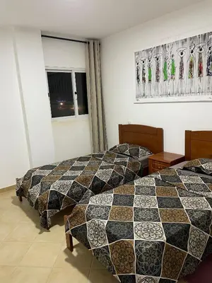 two beds in a hotel room with a checkerboard pattern at SOL AZUL in Santa Maria