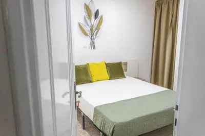 a bedroom with a bed with yellow and green pillows at Apartamento Mágico p/ momentos Memoráveis in Santa Maria