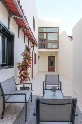 a patio with two chairs and two tables and a building at Apartamento Mágico p/ momentos Memoráveis in Santa Maria
