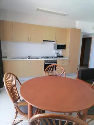 a kitchen with a wooden table and chairs at Solaren Apartments Boavista in Sal Rei