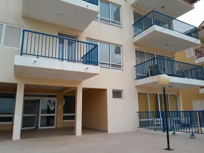 an apartment building with blue balconies and a street light at Solaren Apartments Boavista in Sal Rei