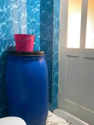 a blue barrel sitting next to a door with a red bucket at Kasa di Terra in Sacramento