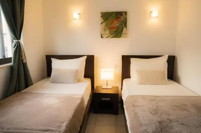 two beds in a bedroom with a lamp on a table at Casa Cubada in Santa Maria