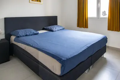 a bed with blue sheets and pillows in a bedroom at Casa Branca Beach in Santa Maria