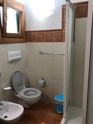 a bathroom with a toilet and a sink at studio's Porto Antigo 2 in Santa Maria