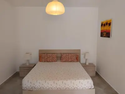 a bedroom with a bed and two night stands at Prostorný a pohodlný apartmán na pláži Cabral in Sal Rei