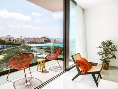 a balcony with chairs and a view of the ocean at Filomena Apartments BOHÈME in Mindelo