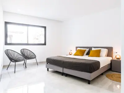 a bedroom with a bed and two chairs at Filomena Apartments BOHÈME in Mindelo
