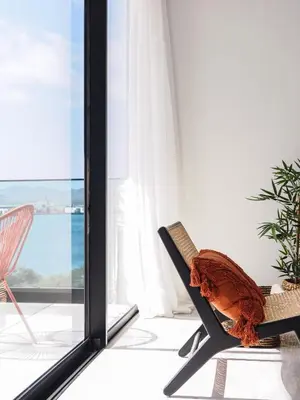 a room with a chair and a window at Filomena Apartments BOHÈME in Mindelo