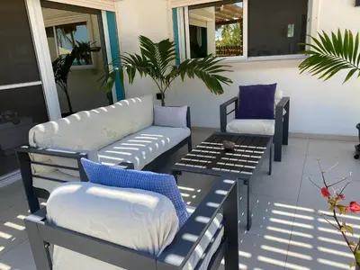 a patio with couches and a table and chairs at Vila Mare - Praia de Chaves frontline in Cabeçadas