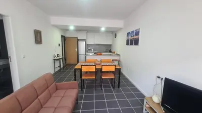 a living room with a couch and tables and a kitchen at Tia Nita Apartamentos in Mindelo