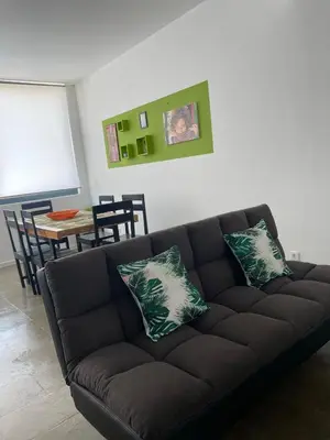 a black couch with two pillows in a living room at Tia Nita Apartamentos in Mindelo